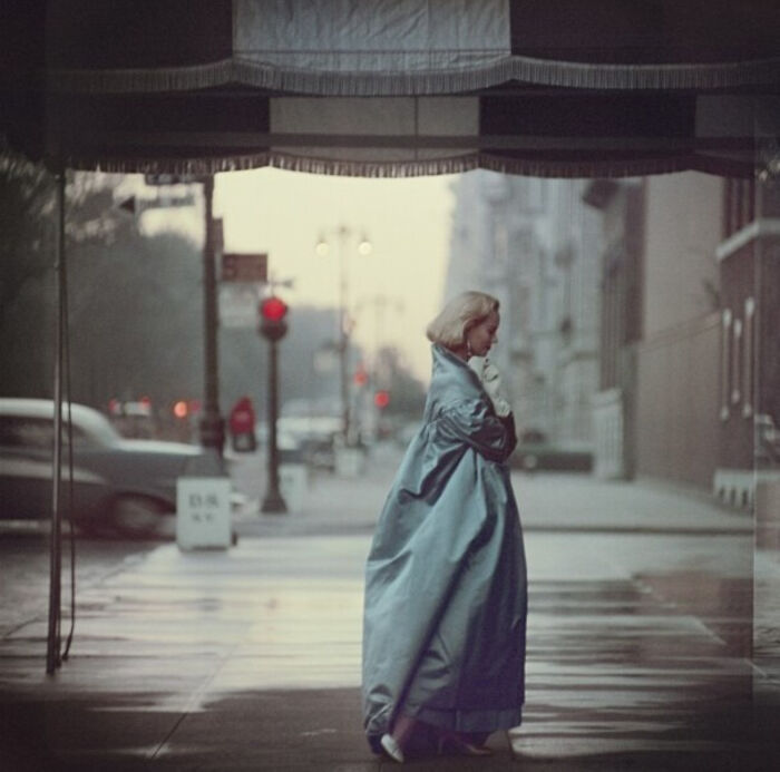 Rare photo of a woman in a long flowing coat on a city street in American history.