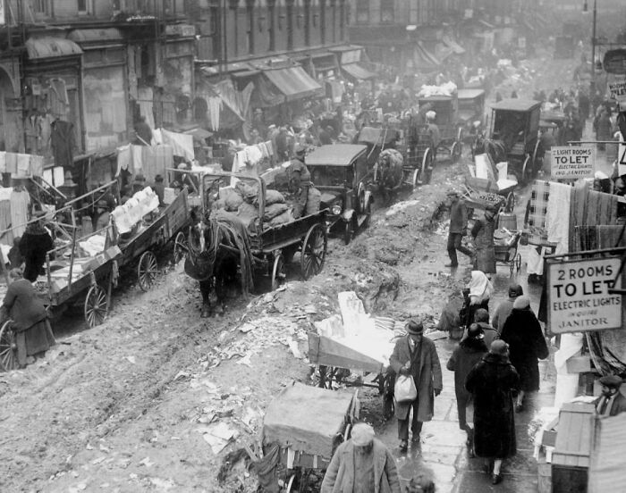 Rare photo from American history depicting a bustling, muddy street market scene with horse-drawn carts and many people.
