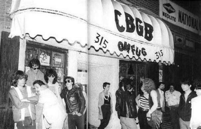 Rare photo from American history of a crowd outside the legendary CBGB music club, showcasing punk rock culture.