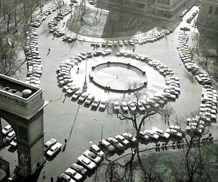 An aerial view of cars parked in a circle around a fountain, a fascinating photo from American history.