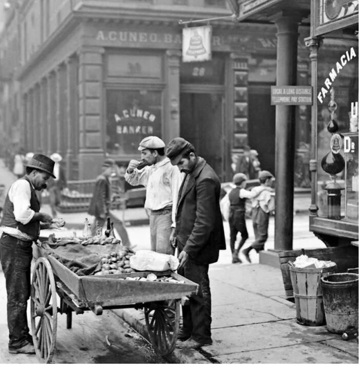 Rare photo of fascinating American street vendors selling produce in a historic urban setting.