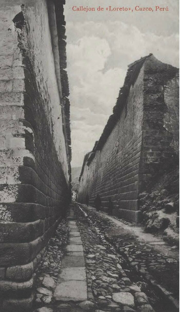A rare and fascinating photo from American history, showing a narrow, ancient street in Cuzco, Peru, with stone walls.