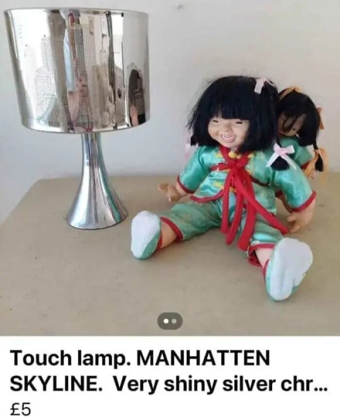 Online marketplace screenshot of a shiny Manhattan skyline touch lamp next to two dolls, showing the weirdest people.