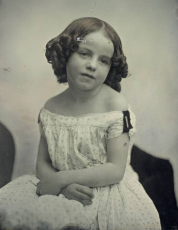 A young Victorian girl with curly hair and a white dress, providing a glimpse into everyday historical photos.