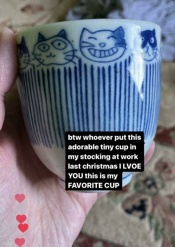 A hand holding a tiny cup with cat designs, a beloved item people lost hope to find.