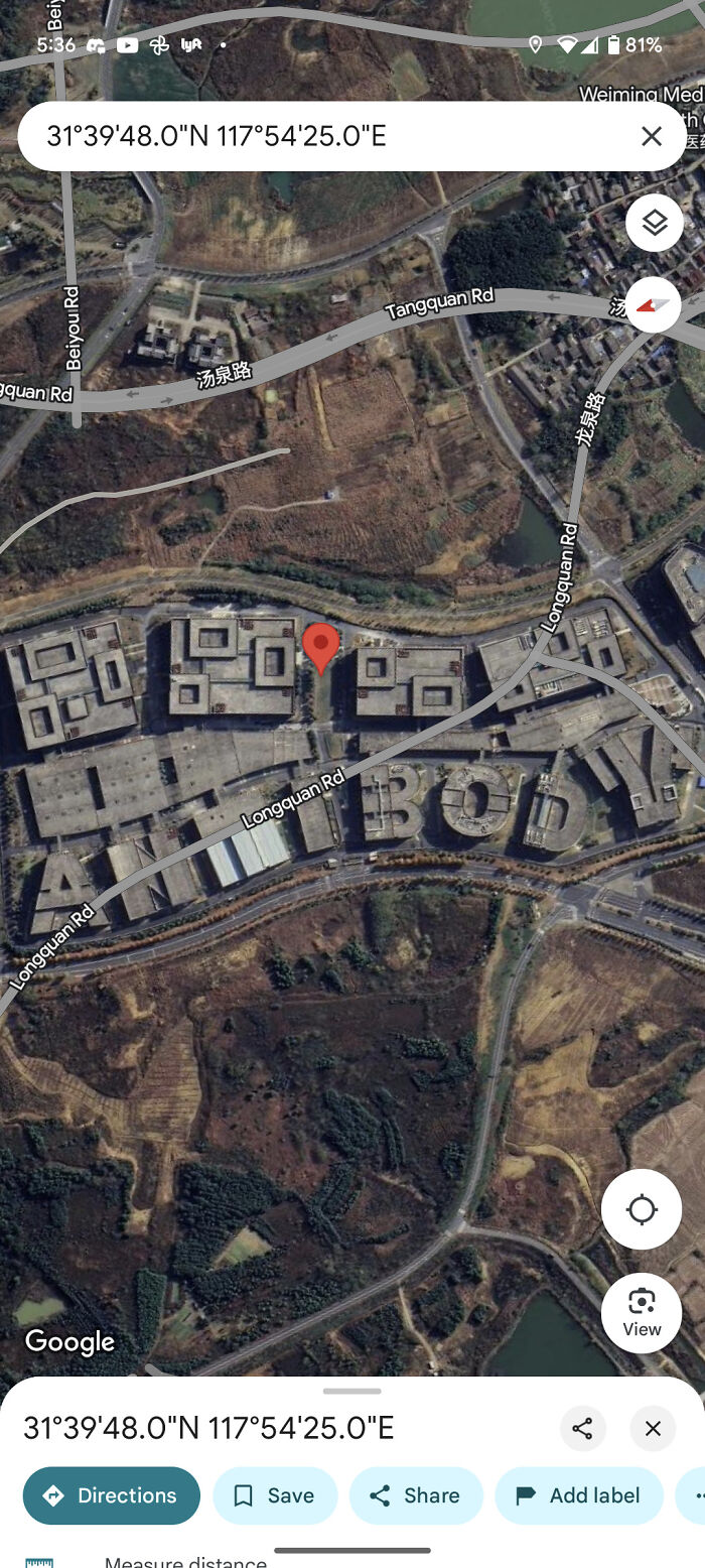 Satellite view from Google Maps showing a building complex spelling out words, an odd find on Google Maps.