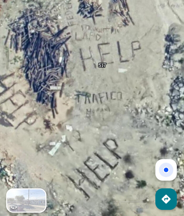 An aerial view from Google Maps showing the word HELP written on the ground amongst debris. People found odd things.