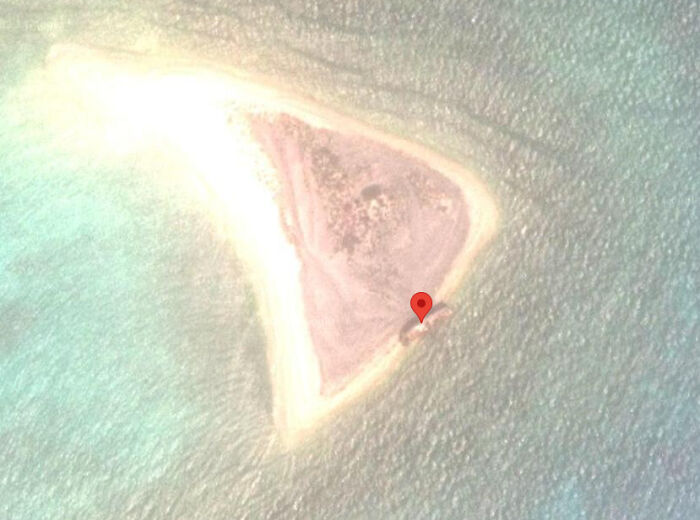 Odd things on Google Maps: A small, triangular island with a red pin marker in turquoise water.