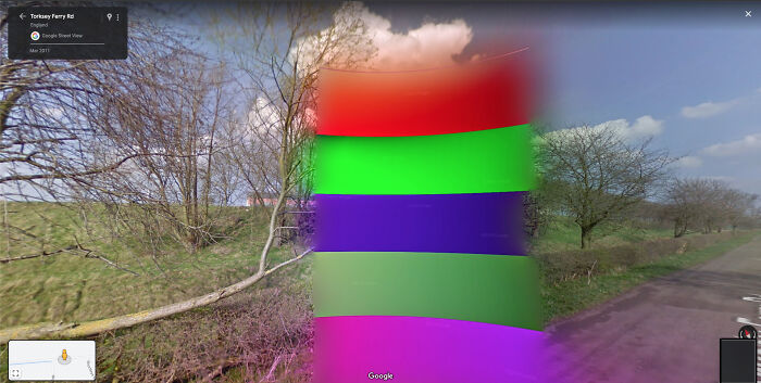 Odd things on Google Maps: a colorful, distorted pillar of red, green, purple, and pink on a rural road.