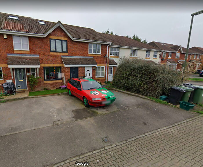 Odd things on Google Maps: a unique red and green car with a custom design parked in front of a house.