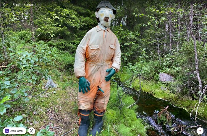 Odd things on Google Maps: a creepy scarecrow with a mustache in a forest next to a stream.