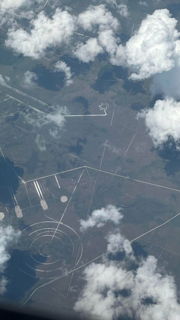 Odd things found on Google Maps: an aerial view through clouds showing strange geometric patterns on the ground.
