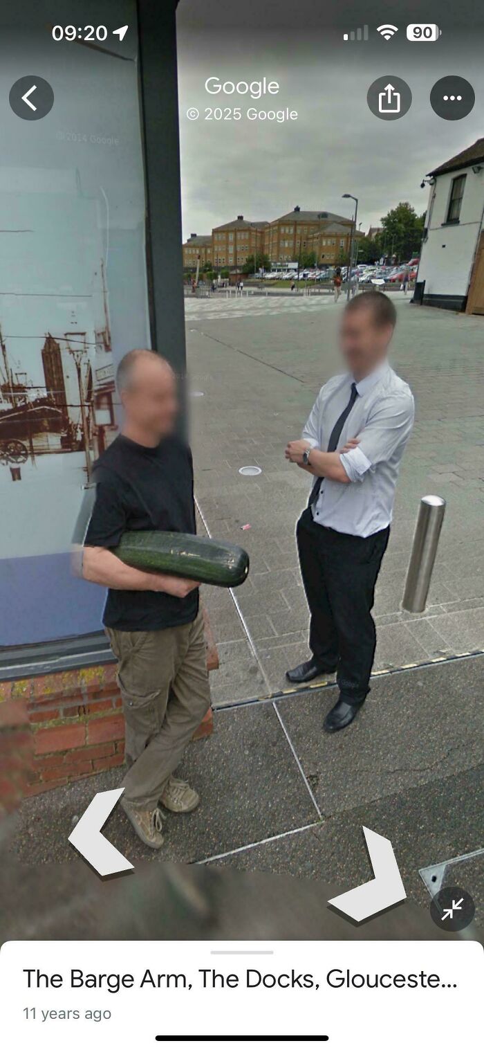 Odd things found on Google Maps: two men on a street, one holding a large zucchini, captured by Google Maps Street View.