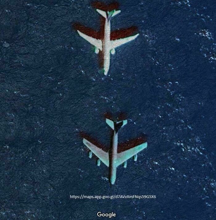Two planes, casting shadows in deep blue water, as seen from Google Maps. People found this odd thing.