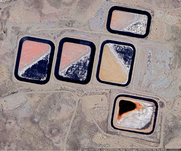 An aerial view from Google Maps shows five colorful, rectangular ponds in a dry landscape, an odd thing found by people.
