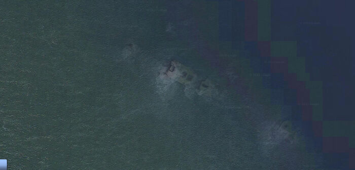 Odd things found on Google Maps: a sunken ship partially visible under the water's surface.