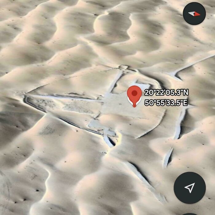 A Google Maps satellite image of an odd structure in a desert, with coordinates, showing unusual desert formations.