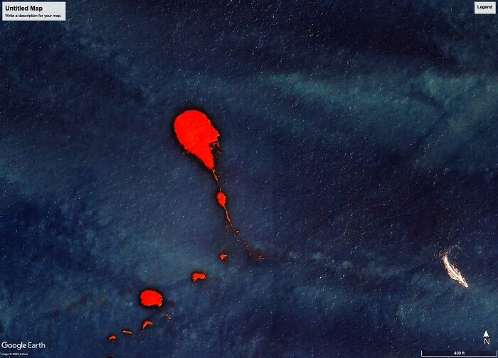 A satellite view from Google Maps showing odd red shapes in the ocean, resembling unusual landmasses or anomalies.