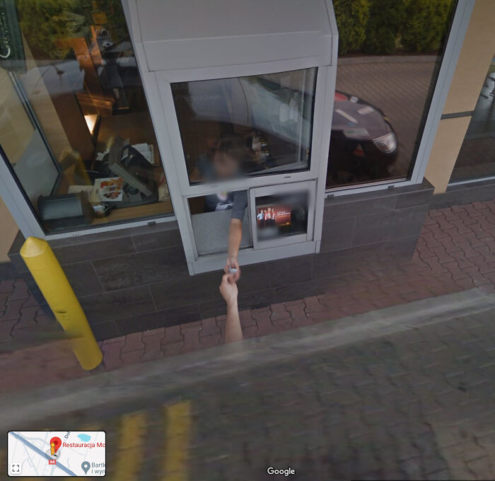 A hand reaching out from a drive-thru window on Google Maps, an odd thing found on Google Maps.