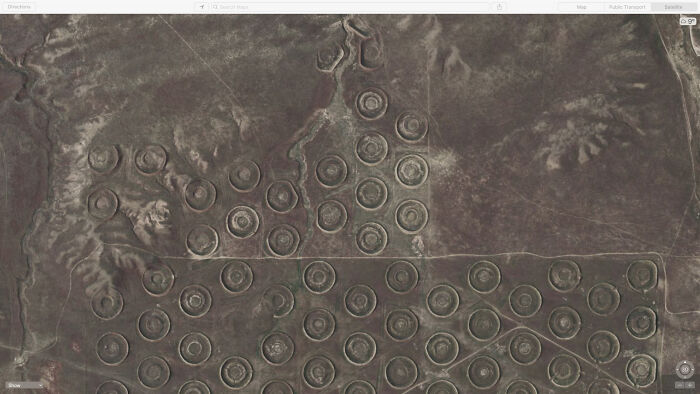 An aerial view of many circular patterns on dry land, an odd thing found on Google Maps.