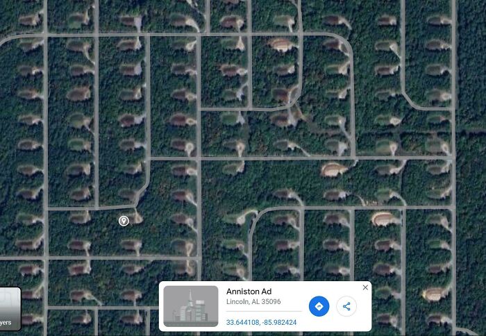 An aerial view from Google Maps showing a grid of suburban homes nestled among trees, an odd sight.