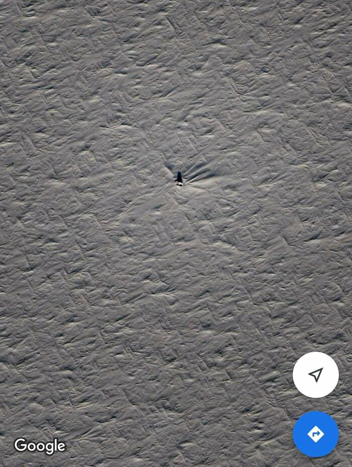 Odd things on Google Maps: a vast, textured gray surface with a small, dark, elongated object casting a shadow.