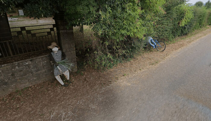 Odd things on Google Maps: a scarecrow by a wall and a bicycle seemingly crashed into a hedge.