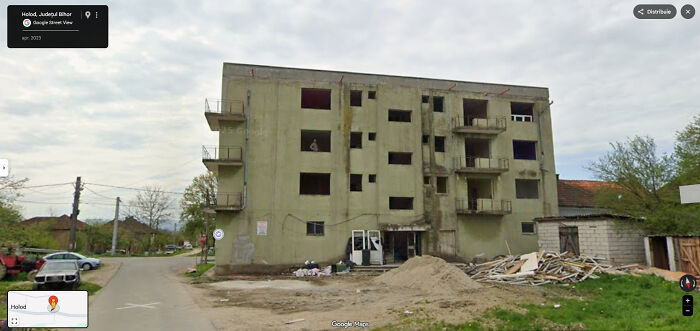 A street-level view on Google Maps of an unfinished or dilapidated apartment building, one of many odd things found on Google Maps.