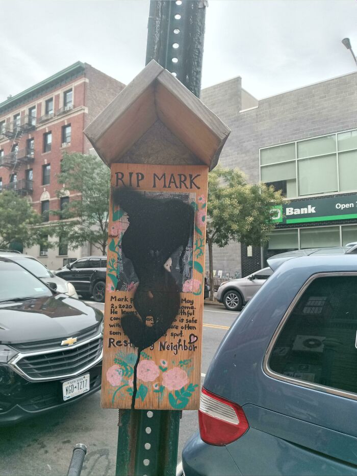 A defaced street memorial sign, symbolizing little hope for humanity.