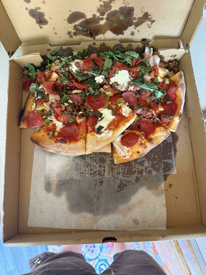 An open pizza box with a half-eaten pizza, messily shifted to one side, showing little hope for humanity.