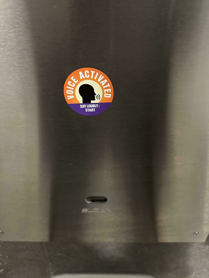 A round, purple and orange voice-activated sticker on a metallic surface, illustrating little hope for humanity in user-friendliness.