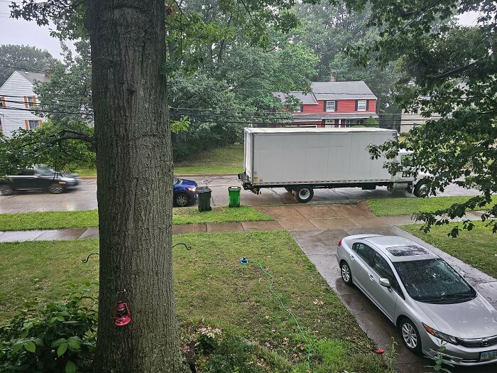 A large moving truck parked on a suburban street, highlighting a reason for little hope for humanity.