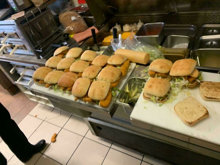 A restaurant counter laden with numerous chicken sandwiches, showing little hope for humanity regarding healthy eating.