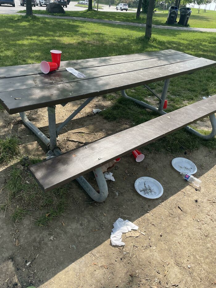 A picnic table covered in trash and plastic cups, showing little hope for humanity.