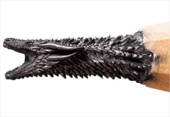 A detailed carving of a dragon head made from a pencil tip, a fascinating find demonstrating intricate art.
