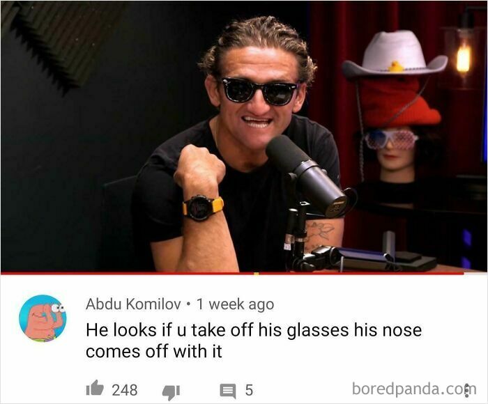 A man in sunglasses and a black shirt talking into a microphone, a subject of funny oddly specific roasts.