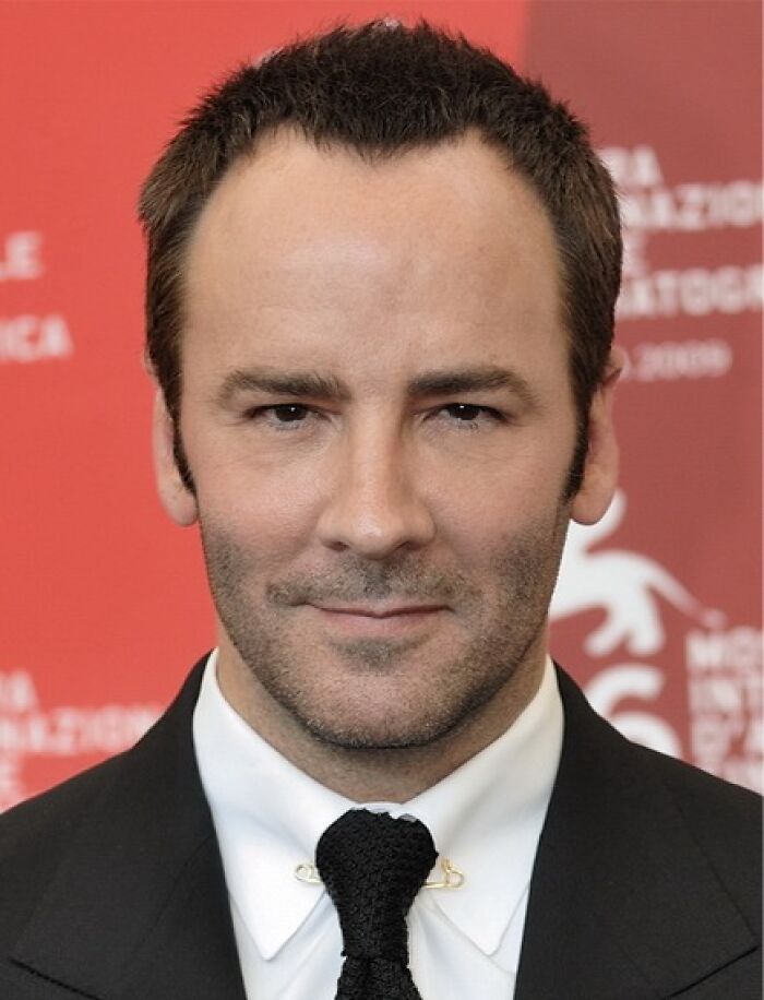 Close-up portrait of Tom Ford in a black suit, white shirt, and black tie, showcasing his bio and career highlights.