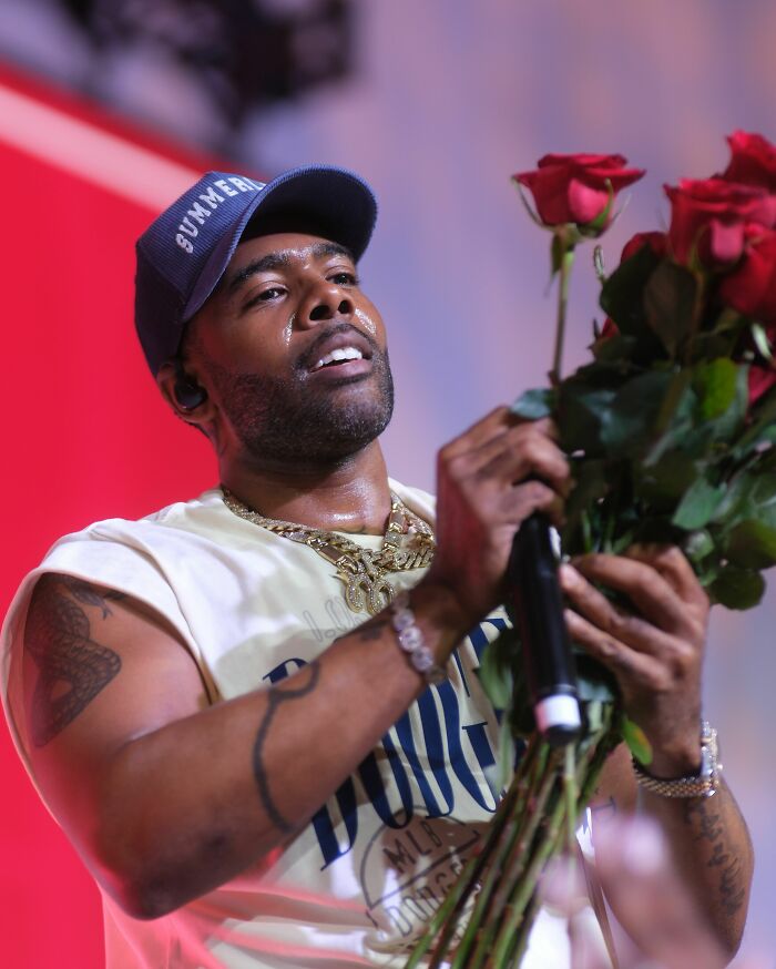 Vocalist Mario holding red roses during a performance, highlighting his career.