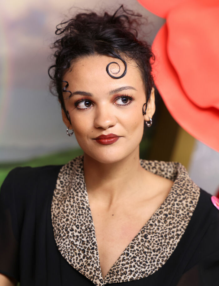 Marissa Bode poses with elaborate hair curls and a leopard-print collar, highlighting her unique style and career.
