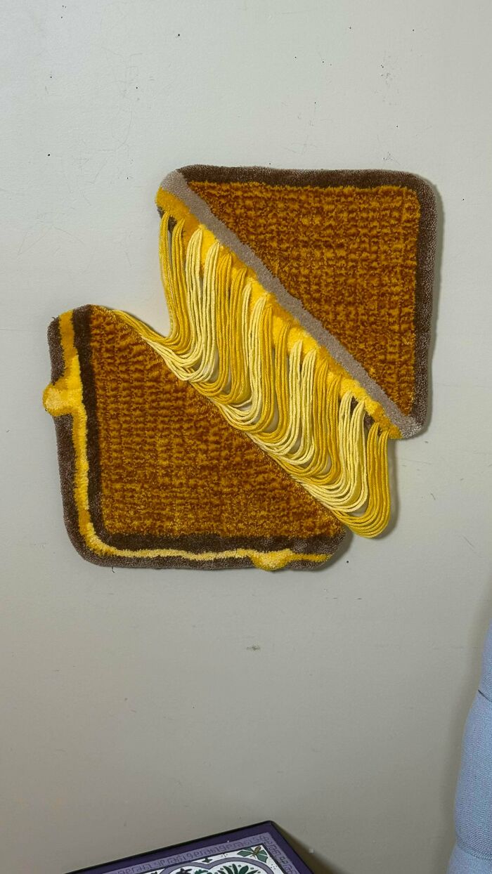 Amazing crafts: a wall-mounted art piece resembling a grilled cheese sandwich with melting cheese made from yarn.