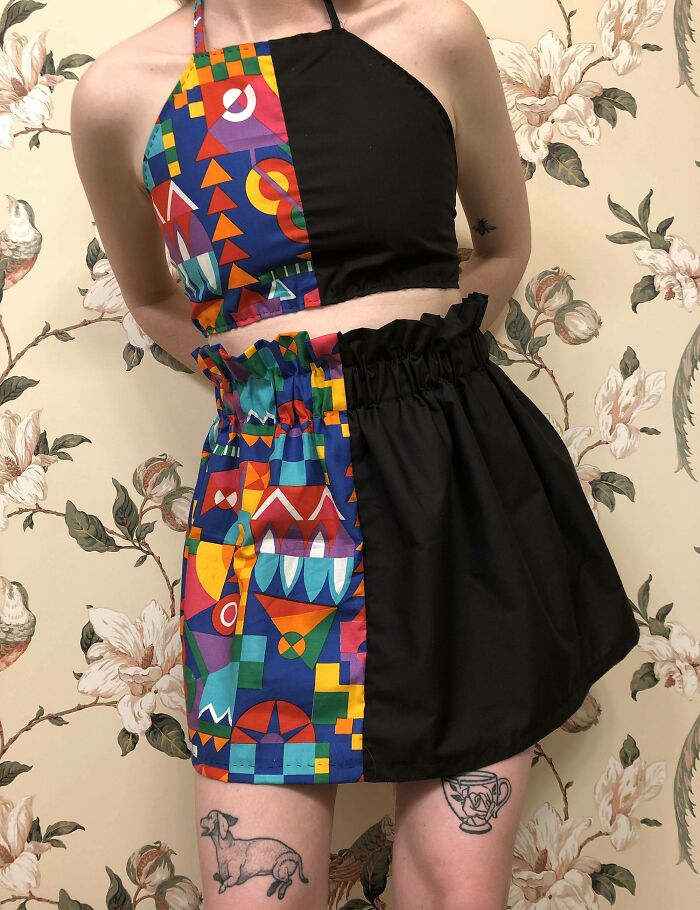 Person in a colorful geometric and black two-piece outfit, showcasing amazing crafts.