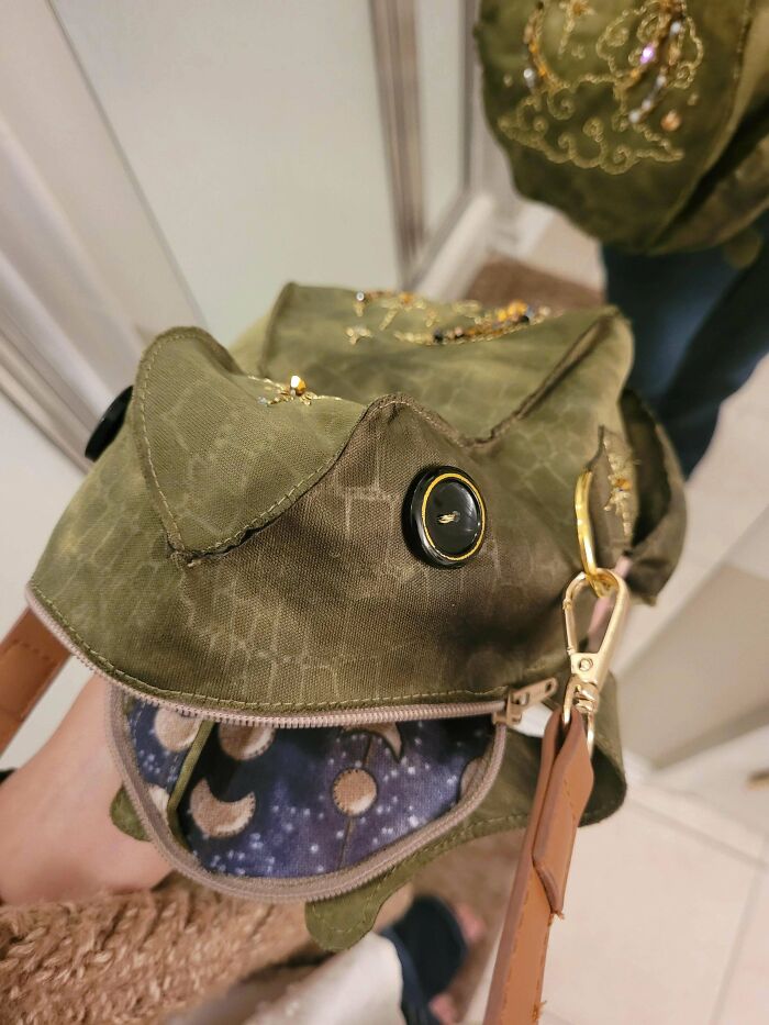 A close-up of a unique frog-shaped handbag with button eyes and intricate stitching, an amazing craft.