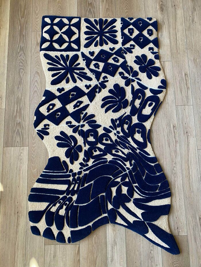An intricately designed blue and white rug with abstract and floral patterns, an amazing craft.