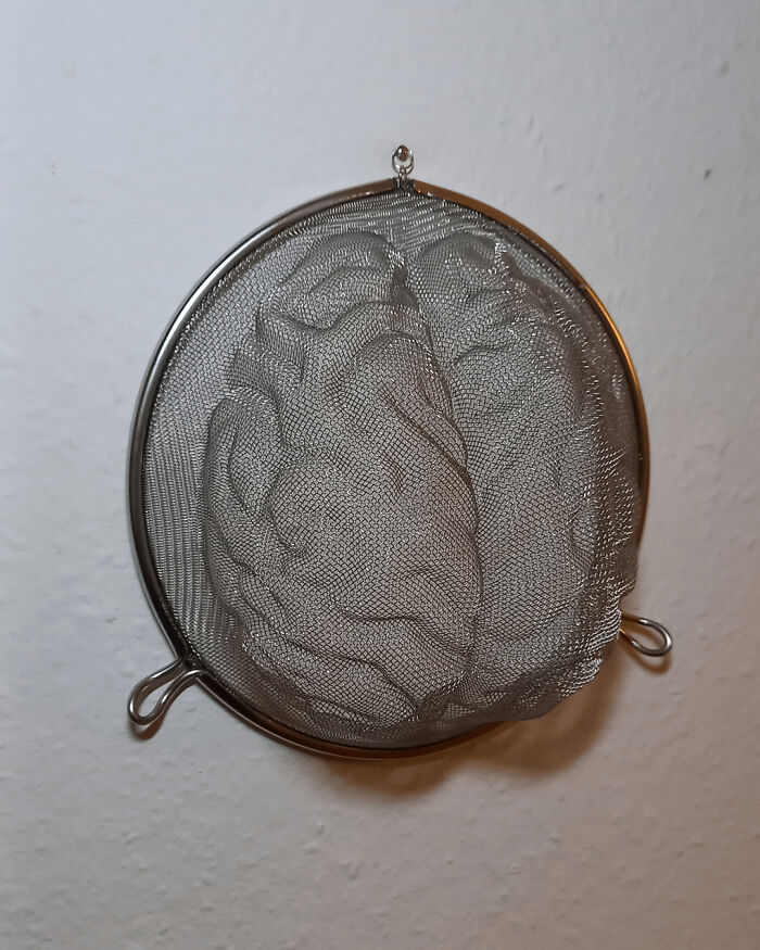 A metal sieve with mesh artfully shaped to resemble a brain, an example of amazing crafts.