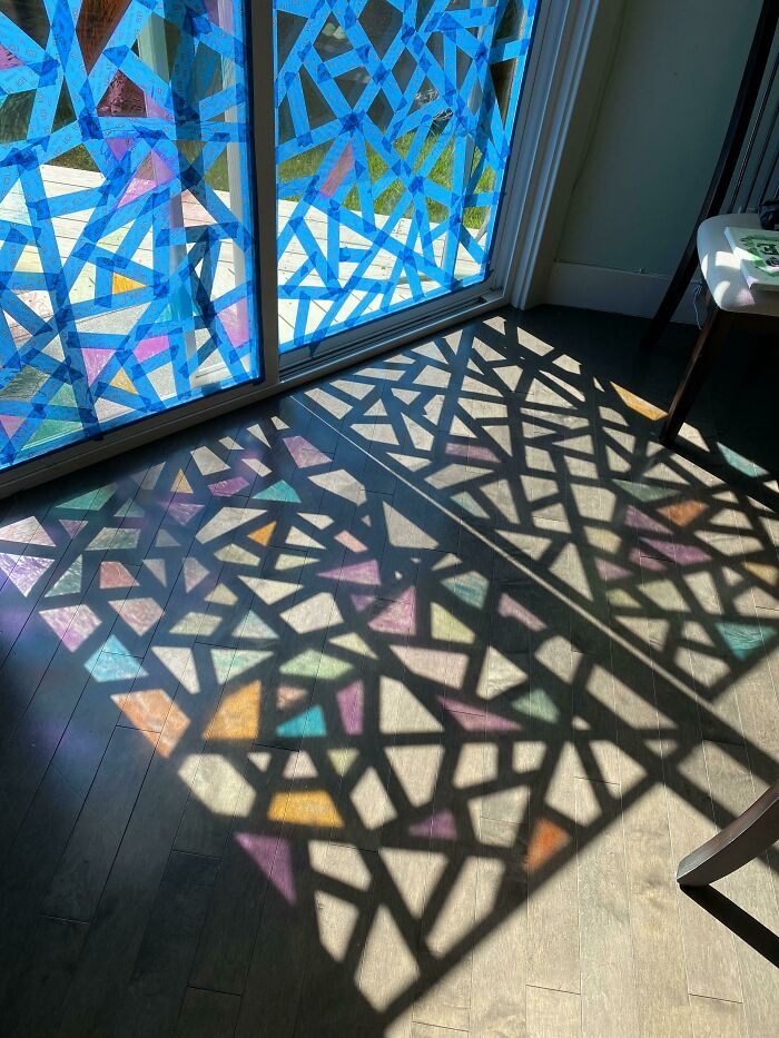 A window covered with colorful crafts tape casting geometric shadows, demonstrating amazing crafts.