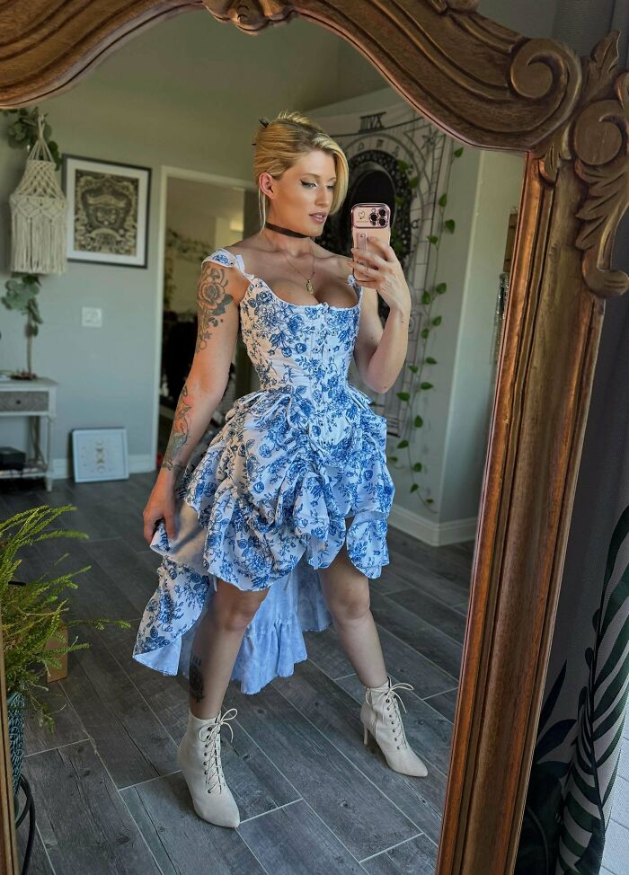 Amazing crafts: A woman taking a selfie in a mirror, showcasing an elaborate blue and white floral dress.