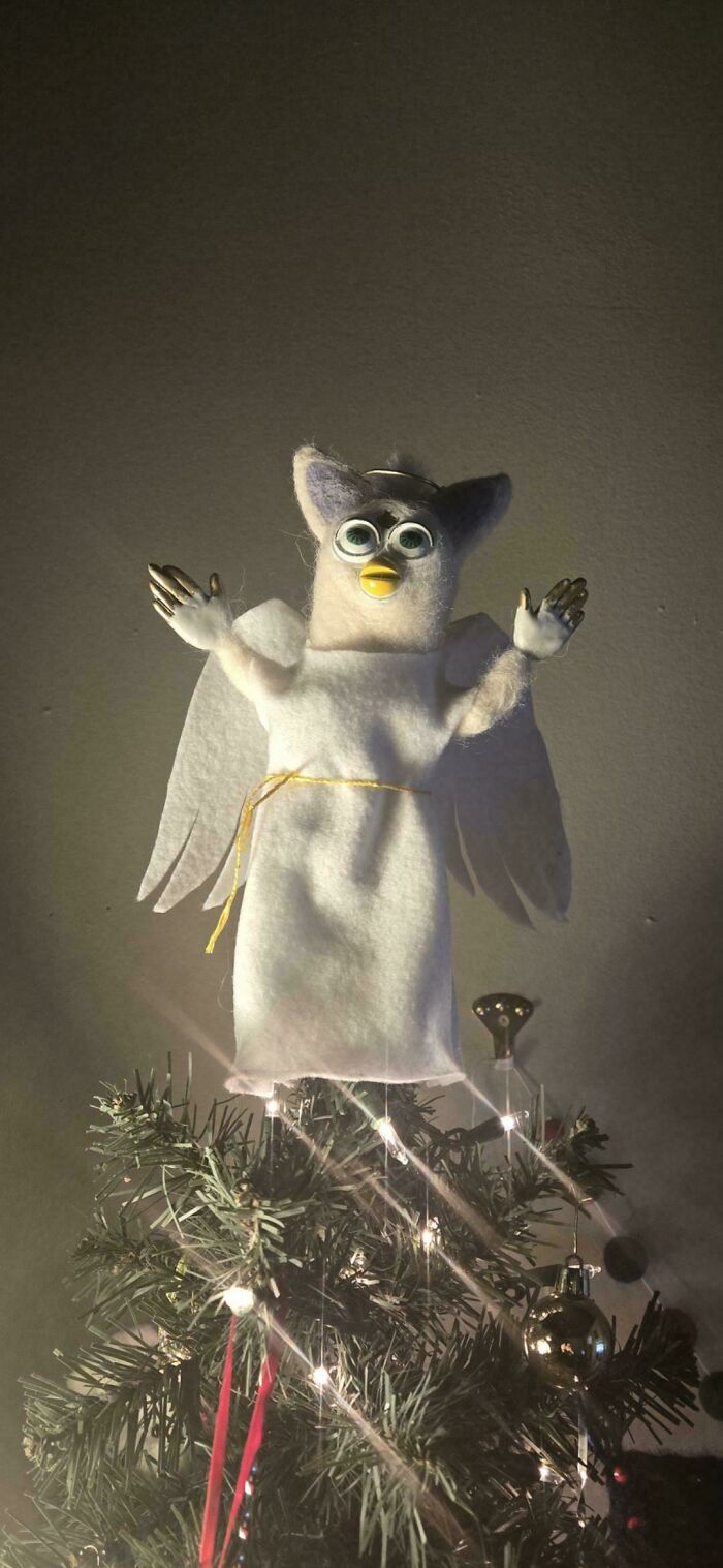 Amazing crafts: a unique angel-winged creature, possibly a repurposed toy, serving as a whimsical Christmas tree topper.