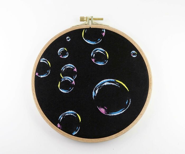 Amazing crafts featuring an embroidery hoop with colorful bubbles on a black background.