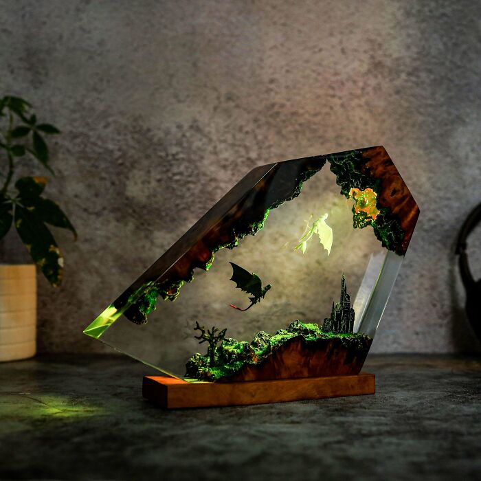 Amazing crafts: a stunning resin diorama featuring dragons and a castle, illuminated beautifully, highlighting artistic skill.