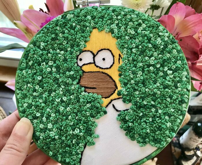 Amazing crafts: Embroidered Homer Simpson peeking through green foliage, demonstrating people's ability to go above and beyond.